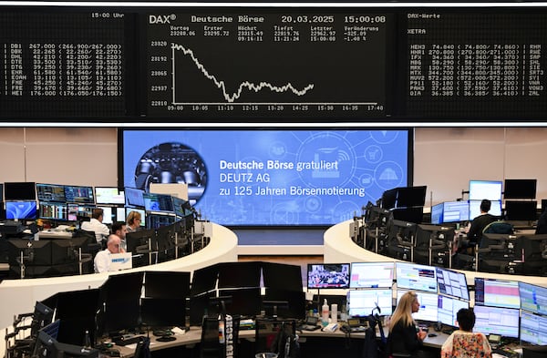 Stock market traders work behind their desks on the trading floor of the Frankfurt Stock Exchange, Germany, Thursday, March 20, 2025. (Arne Dedert/dpa/dpa via AP)