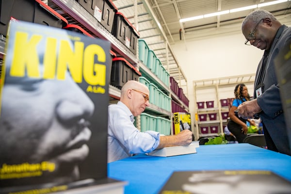 Stockbridge Walmart hosts a book signing and panel discussion on Saturday, Aug 19, 2023, where “King: A Life” author Jonathan Eig, left, autographs a book for Stockbridge council member Alphonso Thomas.  This Walmart location was once a cotton field where King’s father was a sharecrop farmer.  (Jenni Girtman for The Atlanta Journal-Constitution)