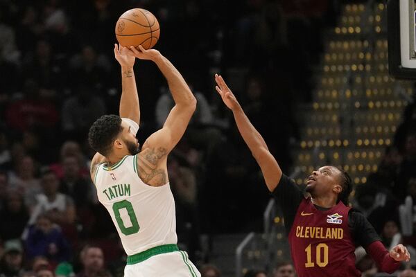 Boston Celtics forward Jayson Tatum (0) shoots over Cleveland Cavaliers guard Darius Garland (10) in the first half of an NBA basketball game, Sunday, Dec. 1, 2024, in Cleveland. (AP Photo/Sue Ogrocki)