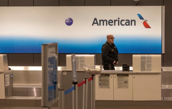 An airport police officer walks behind the American Airlines counter at Wichita's Eisenhower Airport, Wednesday, Jan. 29, 2024, in Wichita, Kan., after news that an American Airlines flight from Wichita collided with a helicopter near Ronald Reagan Washington Airport. (AP Photo/Travis Heying)