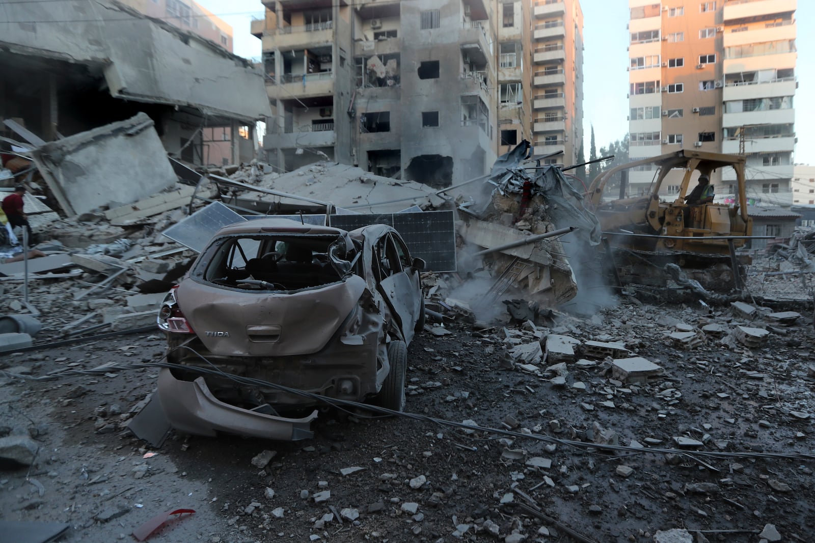 A rescue worker uses a bulldozer to remove the debris of destroyed buildings hit in Israeli airstrikes in Tyre, Lebanon, Monday, Oct. 28, 2024. (AP Photo/Mohammed Zaatari)