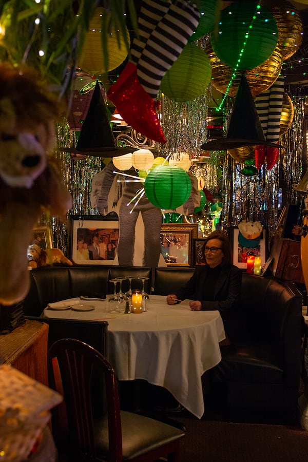 Gale Parker sits in a corner booth decorated in a "Wizard of Oz" theme before service starts at Amore e Amore.
(Lizzie McIntosh Simpson for The Atlanta Journal-Constitution)