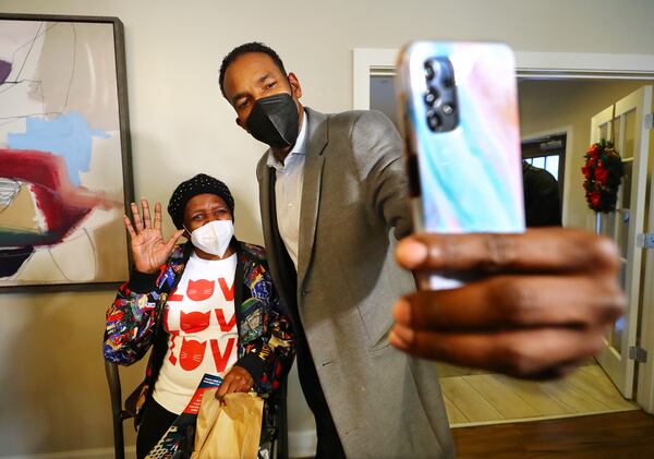 Atlanta mayoral candidate and councilman Andre Dickenson pauses for a selfie with Yolanda Napier while visiting with her and other residents during a campaign stop at The Remington, a senior living facility, on the eve of the mayoral runoff election on Monday, Nov. 29, 2021, in Atlanta.   “Curtis Compton / Curtis.Compton@ajc.com”`