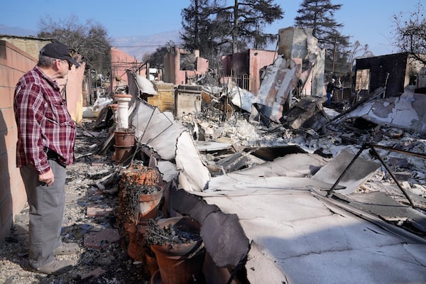 Joel Parkes, a teacher with the Los Angeles Unified School District returns to his destroyed home in the aftermath of the Eaton Fire, Sunday, Jan. 19, 2025, in Altadena, Calif. (AP Photo/Damian Dovarganes)