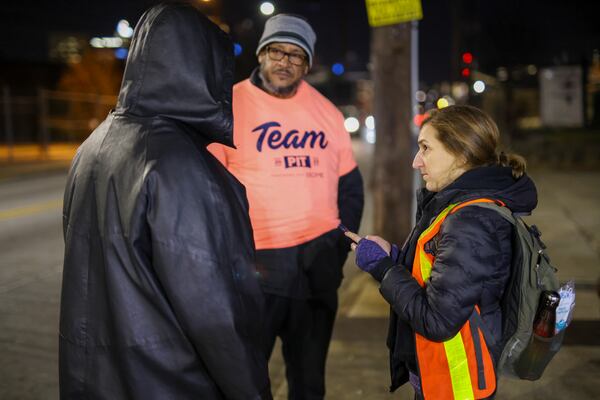 Volunteer Calla Jamison, right, and Jose Sandoval, the director of homeless at Frontline Response Atlanta, center, talks with a man who is homeless. Jason Getz / Jason.Getz@ajc.com)
