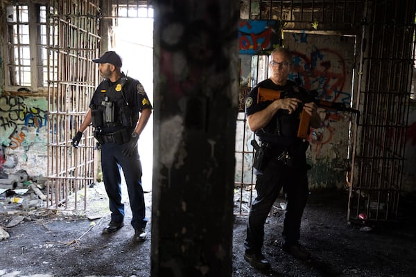 Officers stand in an Old Prison Farm building during an Atlanta Police Department and Atlanta Fire Rescue media tour of the Atlanta Public Safety Training Center Site in Atlanta on Friday, May 26, 2023. (Arvin Temkar / arvin.temkar@ajc.com)