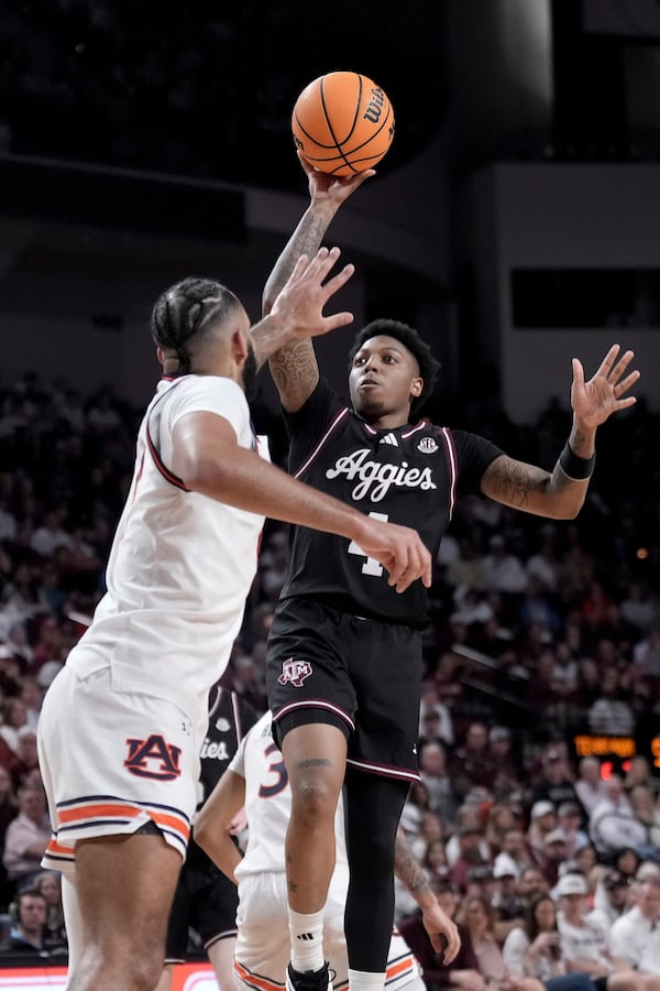 Texas A&M guard Wade Taylor IV shoots a basket over Auburn forward Johni Broome during the first half of an NCAA college basketball game, Tuesday, March 4, 2025, in College Station, Texas. (AP Photo/Sam Craft)