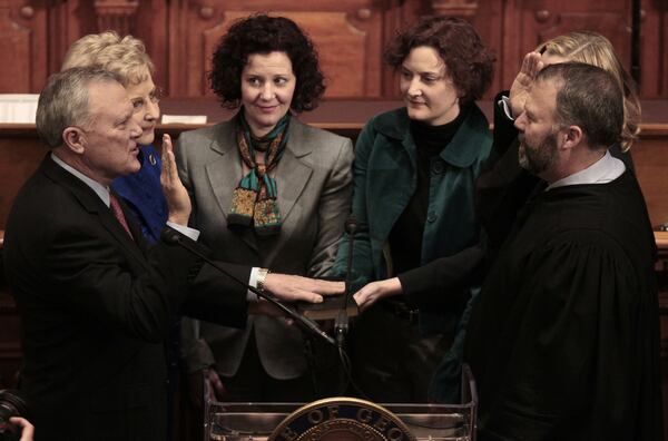 Nathan Deal (left) is sworn in as Georgia’s governor by his son, Hall County Superior Court Judge Jason Deal, on Jan. 10, 2011, in Atlanta. In the back, from left, is the governor’s wife Sandra Deal and daughters Mary Emily O’Bradovich, Carrie Deal Wilder and Katie Deal Wright. (AP Photo/John Bazemore, Pool)