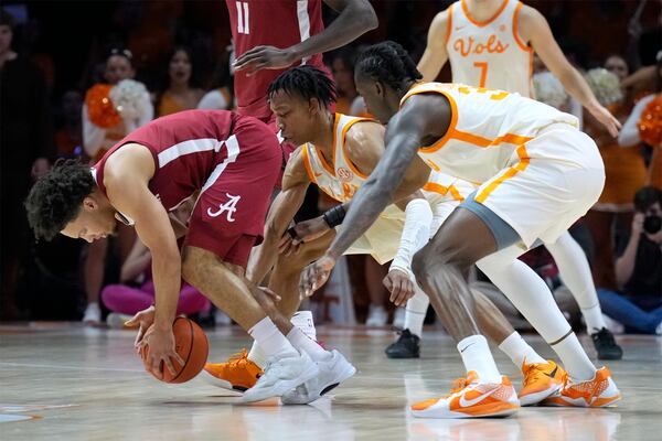 Alabama guard Mark Sears, left, tries to control the ball ahead of Tennessee's Jordan Gainey, center, and Felix Okpara, right, in the first half of an NCAA college basketball game Saturday, March 1, 2025, in Knoxville, Tenn. (AP Photo/Mark Humphrey)