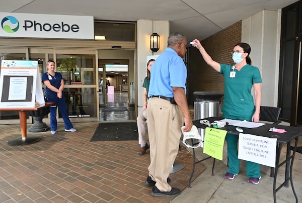 A nurse checks a temperature of an employee before he enters the Phoebe Putney Memorial Hospital in Albany on Tuesday, March 24, 2020. (Hyosub Shin / Hyosub.Shin@ajc.com)