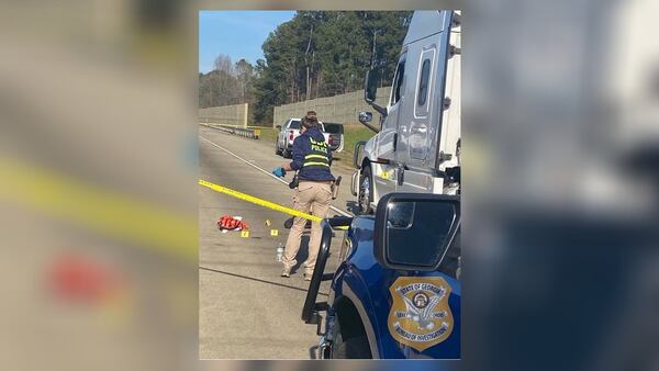 A GBI agent processes the scene of a shooting investigation on I-85 in Coweta County on Tuesday.