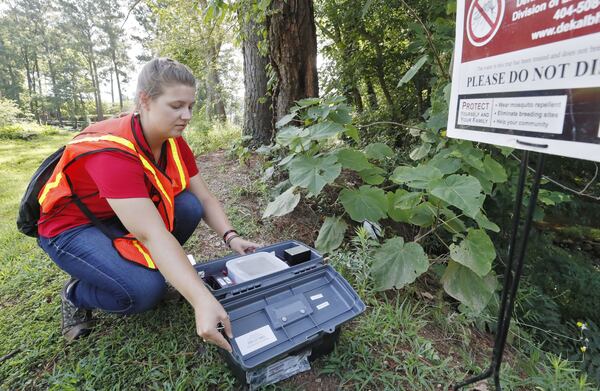 Callie Pierce, a seasonal staff member at the DeKalb County Health Department’s Division of Environmental Health, checks a mosquito trap at Brookside Park. BOB ANDRES / BANDRES@AJC.COM