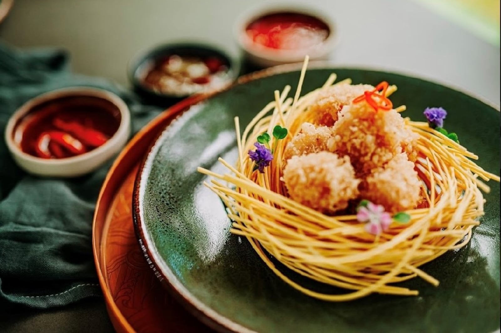 Crispy chicken is served on a bird's nest of fried noodles at the Sparrow in Midtown. Courtesy of the Sparrow