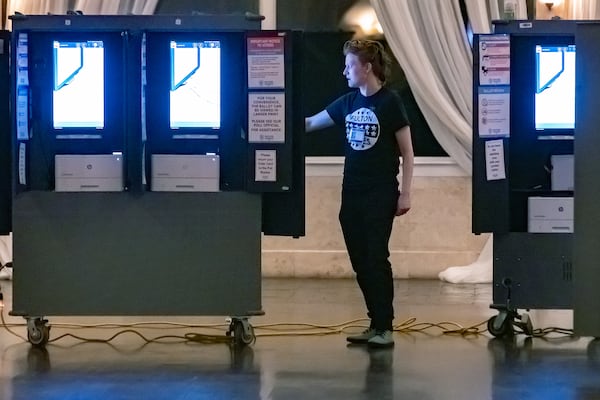 Poll worker Gamble Everett prepares machines in the voting area on Tuesday in Atlanta.