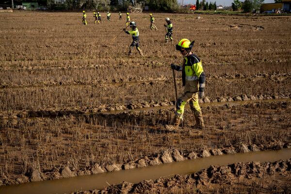 Members of the fire brigade search the area for bodies washed away by the floods in the outskirts of Valencia, Spain, Friday, Nov. 8, 2024. (AP Photo/Emilio Morenatti)