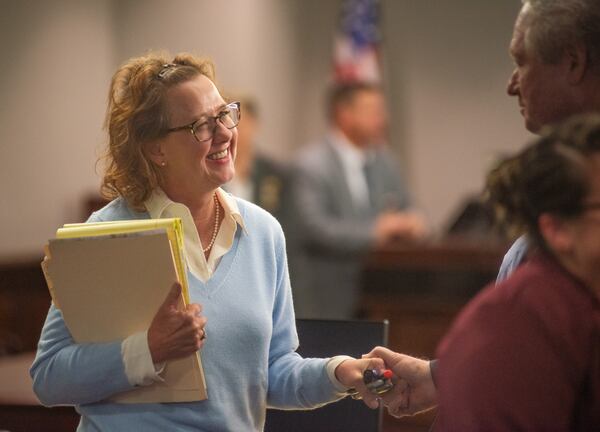 Former District Attorney Jackie Johnson smiles at a supporter who took her hand Monday after Senior Judge John R. Turner dismissed one of the two charges she faced.