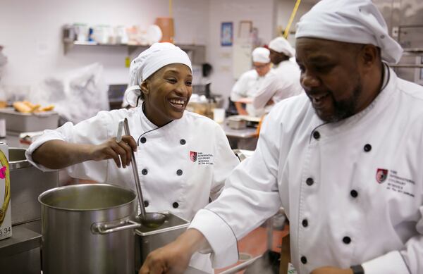 Students Michele Morris, left, and Willie Johnson make dinner in the kitchen at Creations at the Art Institute of Atlanta Tuesday October 25, 2016, in Atlanta, Ga. Creations is student-run restaurant offering a three-course meal. It's an environment for students, under the supervision of chefs, to learn how to cook in and run a restaurant. This is for the April 2017 issue of Living Northside. PHOTO / JASON GETZ