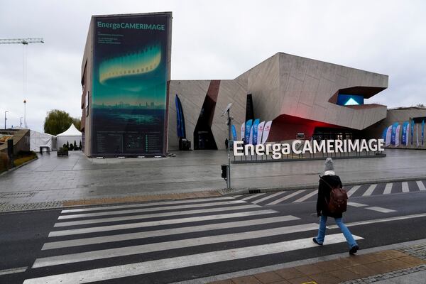 A person walks in front of the venue of the 32nd Camerimage International Film Festival in Torun, Poland, Wednesday, Nov. 20, 2024. (AP Photo/Czarek Sokolowski)