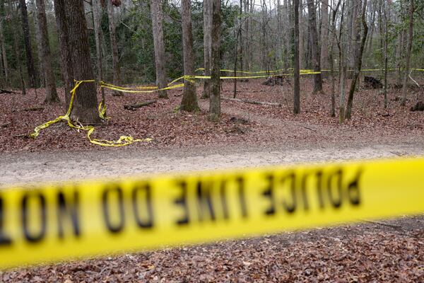 Police tape ropes off the crime scene on a trail behind Lake Herrick in Athens at the University of Georgia on Friday, Feb. 23, 2024. A female nursing student was found dead nearby on Thursday. (Jason Getz / jason.getz@ajc.com)