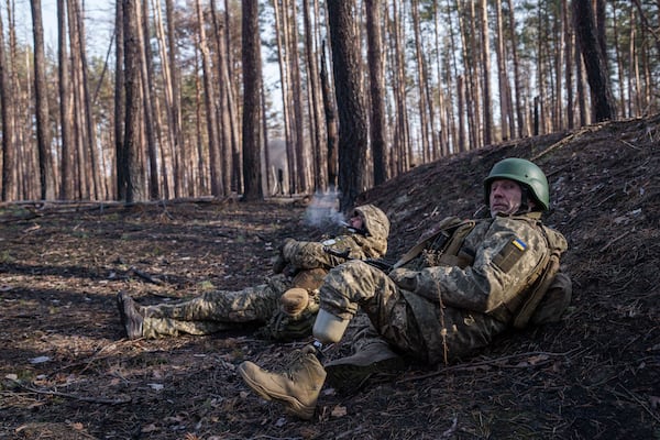 Andrii Serhieiev, foreground, a Ukrainian soldier with the 53rd brigade who lost a leg in battle, works with another soldier to detonate unexploded ordnance near the front line in Ukraine's Donetsk region on Feb. 13, 2025. (AP Photo/Evgeniy Maloletka)