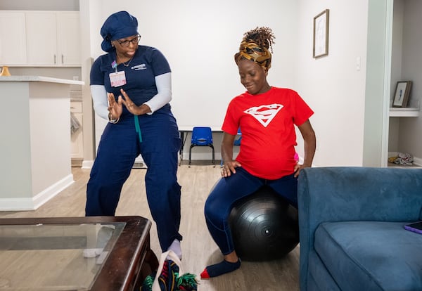 Doula Bashellia Williams (left) walks her client, Reona Porter, through laboring positions at Porter’s Stockbridge apartment on Oct. 8. Porter has just over 38 weeks pregnant. Bita Honarvar for The Atlanta Journal-Constitution