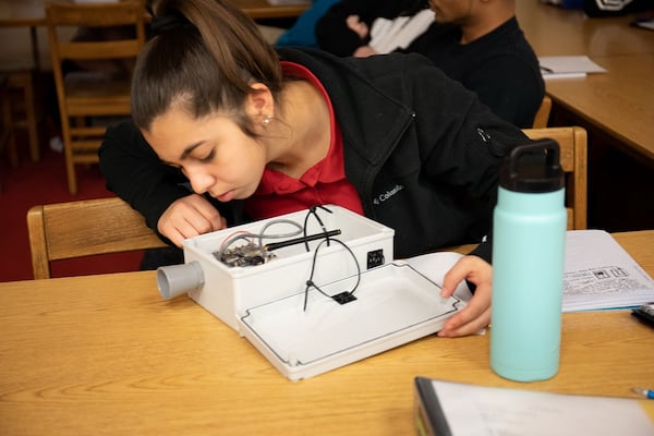 Jenkins High School senior Isabel Smith inspects a prototype water level sensor on Jan. 28, before helping to lead the Savannah school’s sensor building project. Engineering teacher Tom Maty partnered with Georgia Tech to build the devices, which are being placed on bridges and docks around Chatham County to record the way local flood patterns are changing as the planet warms. SHANNON O’KEEFE/ABSHIRE PUBLIC RELATIONS