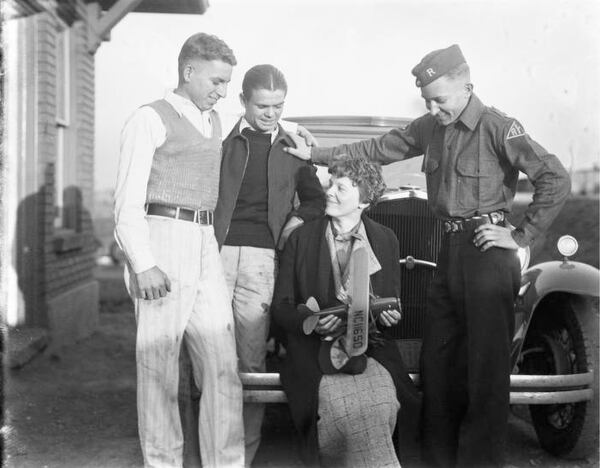 Amelia Earhart holds a model airplane while talking with three unidentified men at Candler Field Airport at an event in 1934. (George Cornett / AJC Archive at GSU Library AJCN030-070b)