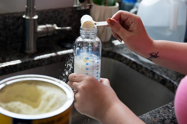 Caitlin Joyce prepares a bottle of baby formula in Plymouth, Mass., May 15, 2022.  (Kayana Szymczak/The New York Times)