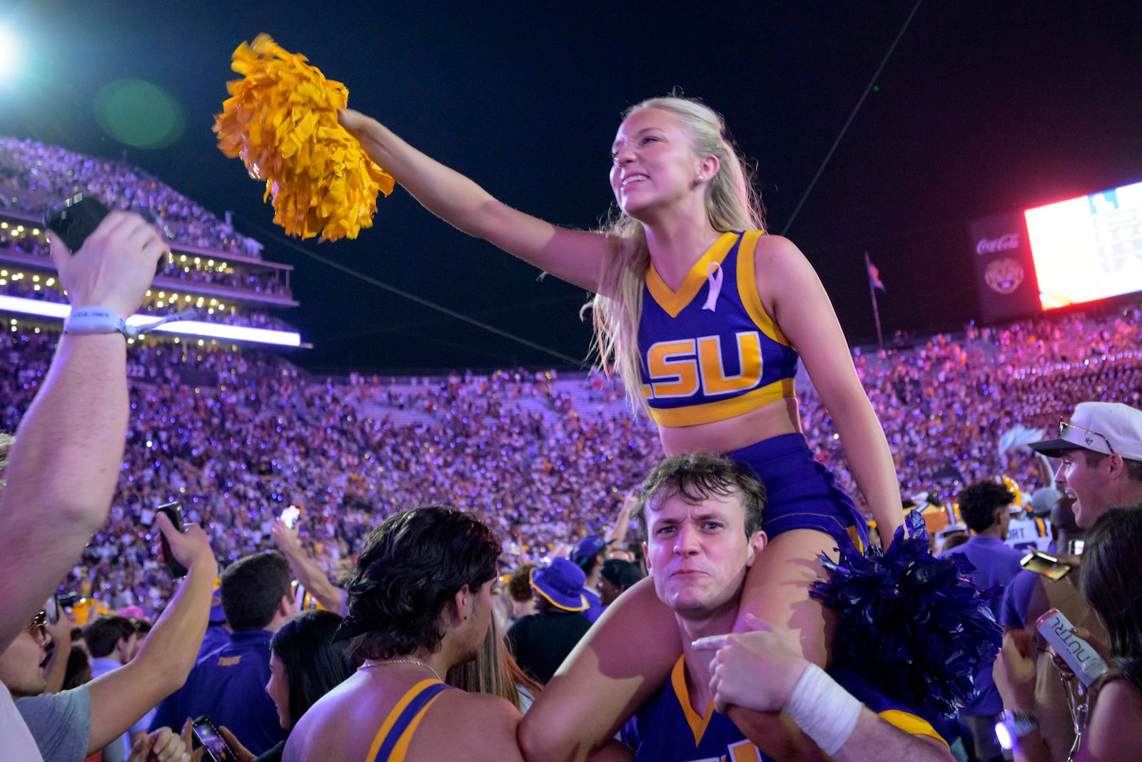 LSU cheerleaders and fans celebrate after the fans rushed the field in the team's overtime victory over Mississippi during an NCAA college football game in Baton Rouge, La., Saturday, Oct. 12, 2024. (AP Photo/Matthew Hinton)