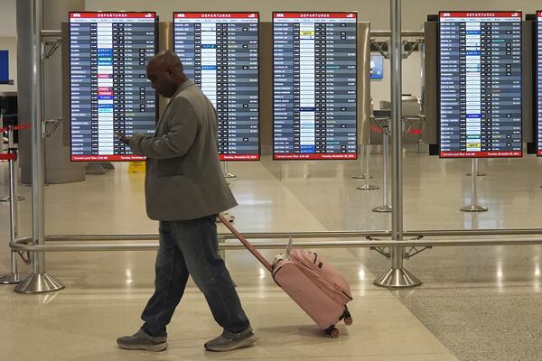 A traveler walks to his gate at Miami International Airport, Tuesday, Nov. 26, 2024, in Miami. (AP Photo/Marta Lavandier)