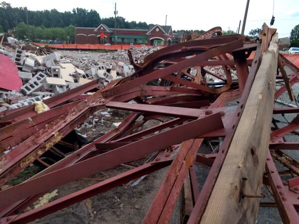 Portions of metal work from the store were seen Saturday. Across the street is a shopping center that includes a Walgreens store.