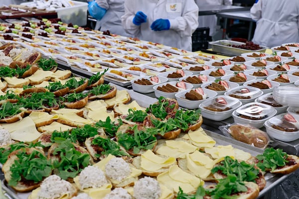 Mainline Aviation employees plate meals for in-flight catering on Friday, August 5, 2022. (Natrice Miller/natrice.miller@ajc.com)