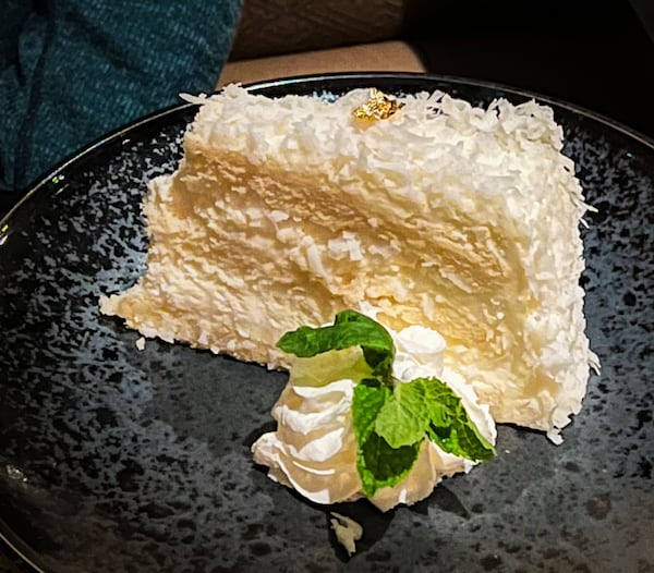 Gold leaf adorns a slice of coconut cake at Nan Thai Buckhead. (Henri Hollis/henri.hollis@ajc.com)