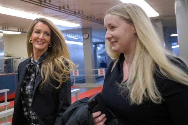 Former U.S. Sen. Kelly Loeffler of Georgia (left) makes her way through the Senate subway in Washington. She is the nominee to lead the Small Business Administration.