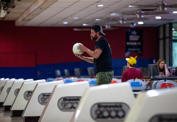 Ryan Lowery prepares to roll a bowling ball, Friday, April 24, 2020 in Douglasville, Ga. Gov. Kemp announced that gyms, barber shops, hair salons, tattoo parlors and bowling alleys can all reopen to help relieve strain on Georgia’s economy. BRANDEN CAMP/SPECIAL