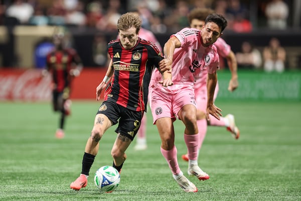 Atlanta United midfielder Saba Lobzhanidze (9) fights for the ball against Inter Miami defender Gonzalo Luján (2), during the second half of an MLS soccer match, Sunday, March 16, 2025, in Atlanta. (AP Photo/Colin Hubbard)