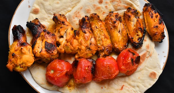 Zafron Wings (grilled with spicy lemon sauce). The wings are accompanied with grilled Roma tomatoes. (Styling by Peter Teimori / Chris Hunt for the AJC) 