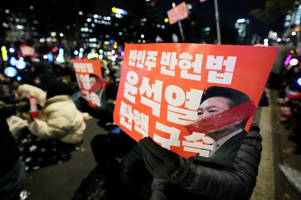 Participants hold banners during a rally to demand South Korean President Yoon Suk Yeol's impeachment outside the National Assembly in Seoul, South Korea, Friday, Dec. 13, 2024. The signs read "Arrest and impeach the rebellion leader Yoon Suk Yeol." (AP Photo/Ahn Young-joon)