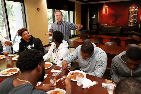 Coach Saban checks in on players during the team's annual Steak and Beans dinner