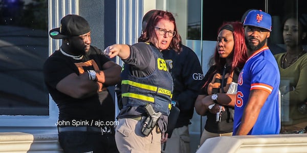 A GBI agent speaks with the shooting victim's family members. JOHN SPINK / JSPINK@AJC.COM