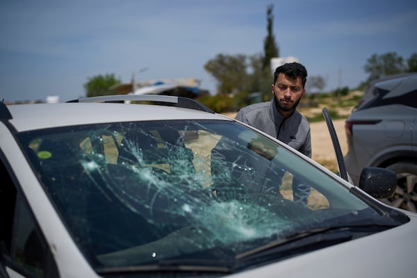 Basel Adra, Palestinian co-director of the Oscar winner documentary "No Other Land", looks at a damaged car after a settler's attack in the village of Susiya in Masafer Yatta, south Hebron hills Tuesday, March 25, 2025. (AP Photo/Leo Correa)