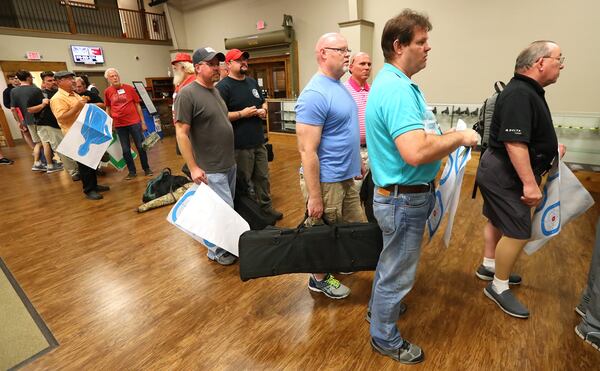 Men line up for the gun range following the Community Bible Church monthly men’s study group at the American Heritage Gun Range in McDonough. CURTIS COMPTON / CCOMPTON@AJC.COM