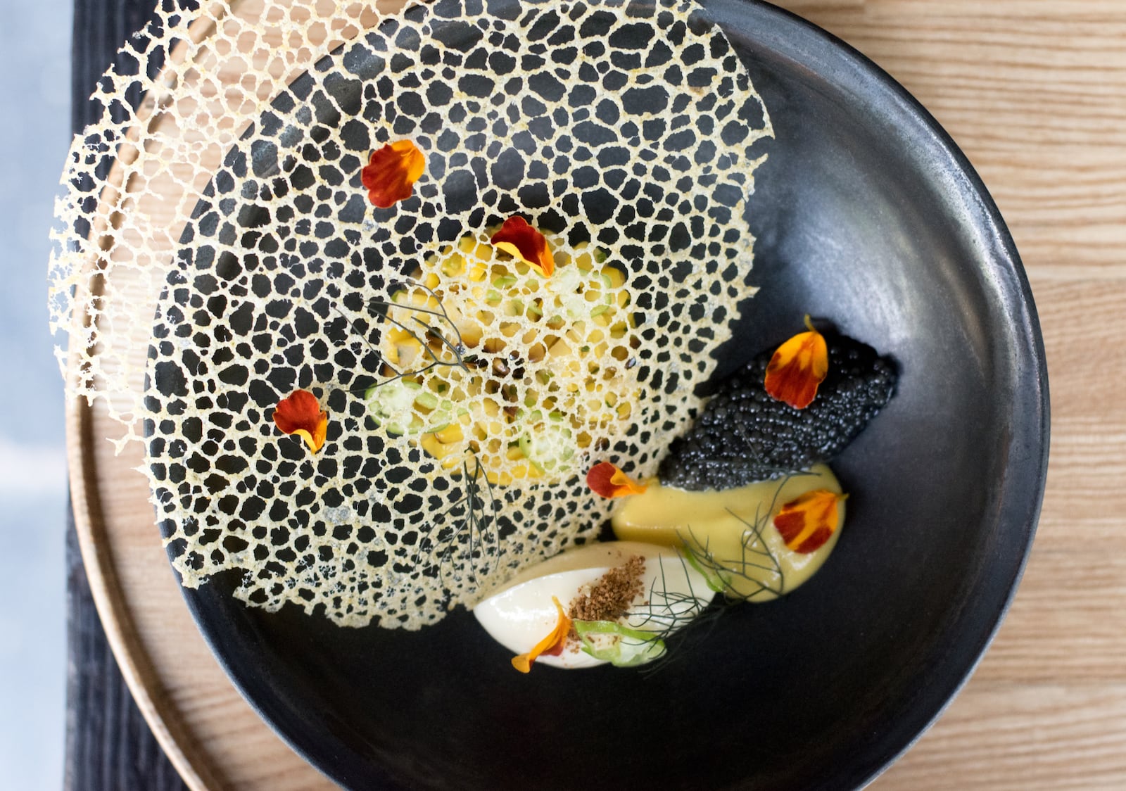 A first course of local sweet corn includes a delicate lace tuile covering the corn pudding and spoonful of paddlefish caviar. CONTRIBUTED BY HENRI HOLLIS