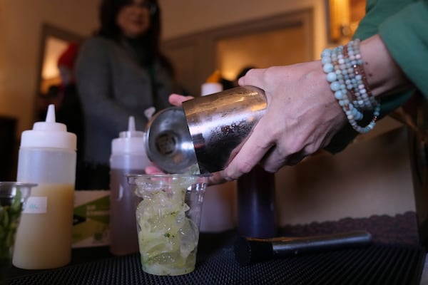 Jeanmarie Holmes of the Dragonfly Cafe pours a Kiwi Mule mocktail, made without tequila, during the sober Saint Patrick's Day celebration at the Whistler House Museum, Thursday, March 13, 2025, in Lowell, Mass. (AP Photo/Charles Krupa)