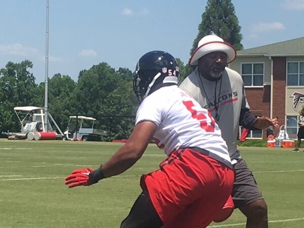 Falcons defensive line coach Bryan Cox working with a player in a pass rush agility drill on Monday. (By D. Orlando Ledbetter/dledbetter@ajc.com)