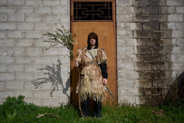 Christos Tomaras, 16, poses for a portrait, dressed in animal skins and heavy bronze bells, as part of carnival celebrations in Distomo, a village in central Greece, on Monday, March 3, 2025. (AP Photo/Petros Giannakouris)