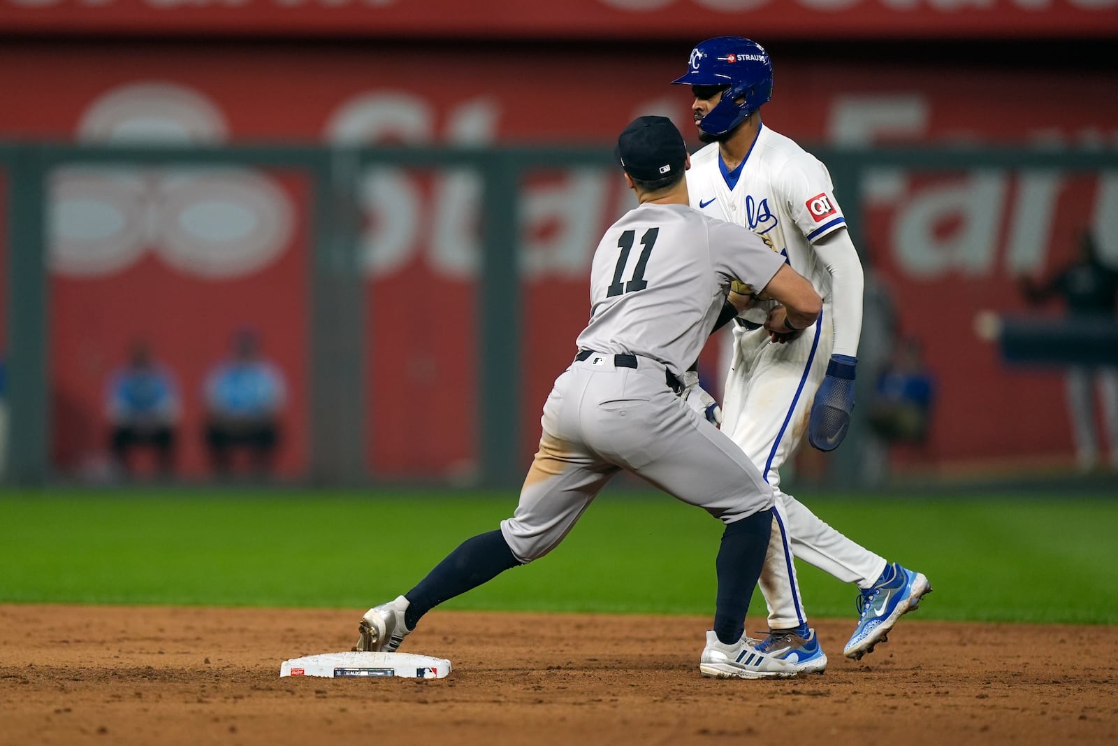 Kansas City Royals' Maikel Garcia, right, stands up after being tagged out at second by New York Yankees shortstop Anthony Volpe, left, on a double play during the sixth inning in Game 4 of an American League Division baseball playoff series Thursday, Oct. 10, 2024, in Kansas City, Mo. The Royals' Michael Massey was out at first. (AP Photo/Charlie Riedel)