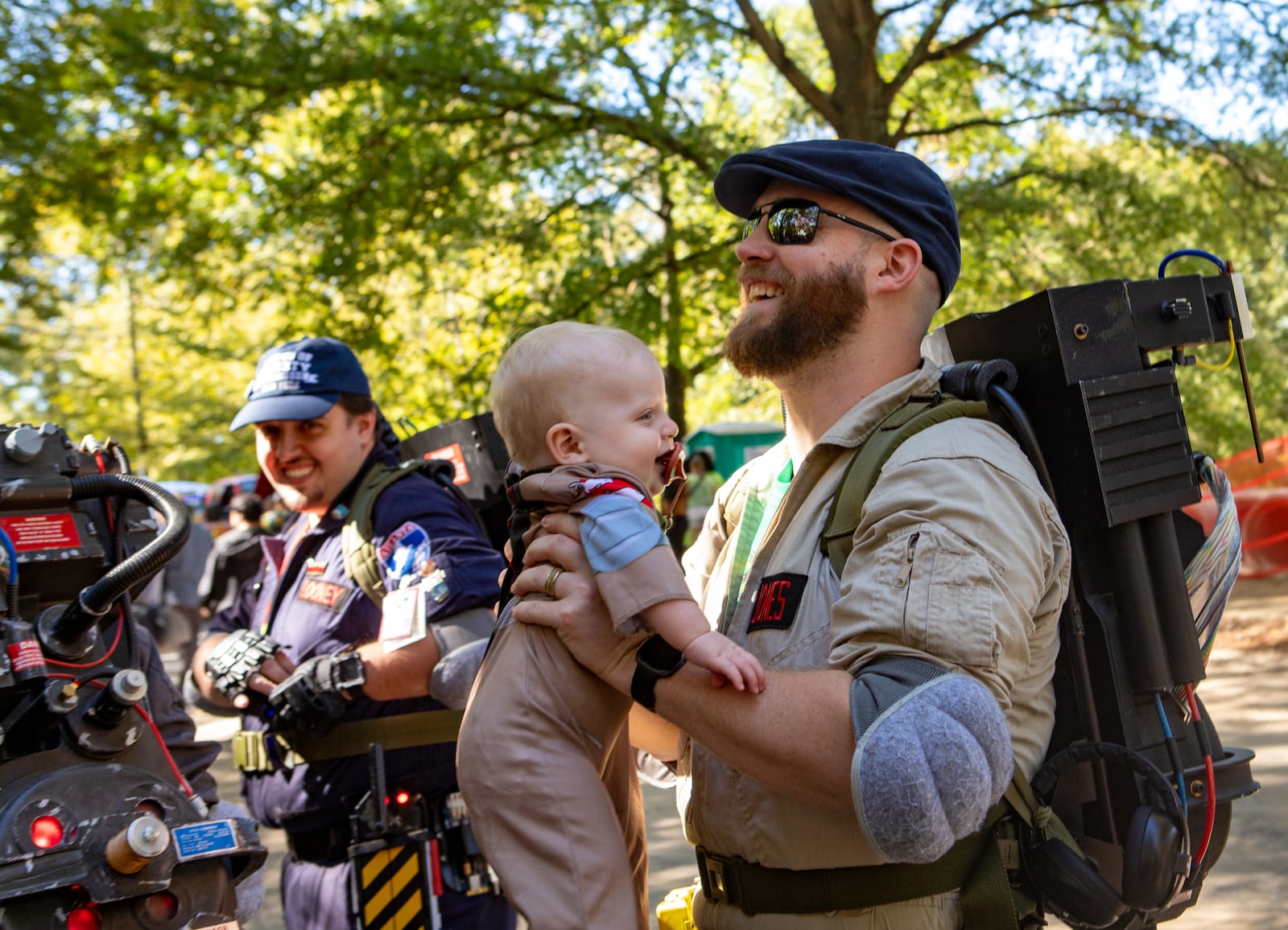 The Atlanta Ghostbusters gather on Euclid Avenue before the annual Little 5 Points Halloween Parade where Marcus Jones keeps his 8-month old son, Logan Jones, busy before the parade begins on Sunday, Oct 20, 2024. (Jenni Girtman for the AJC)