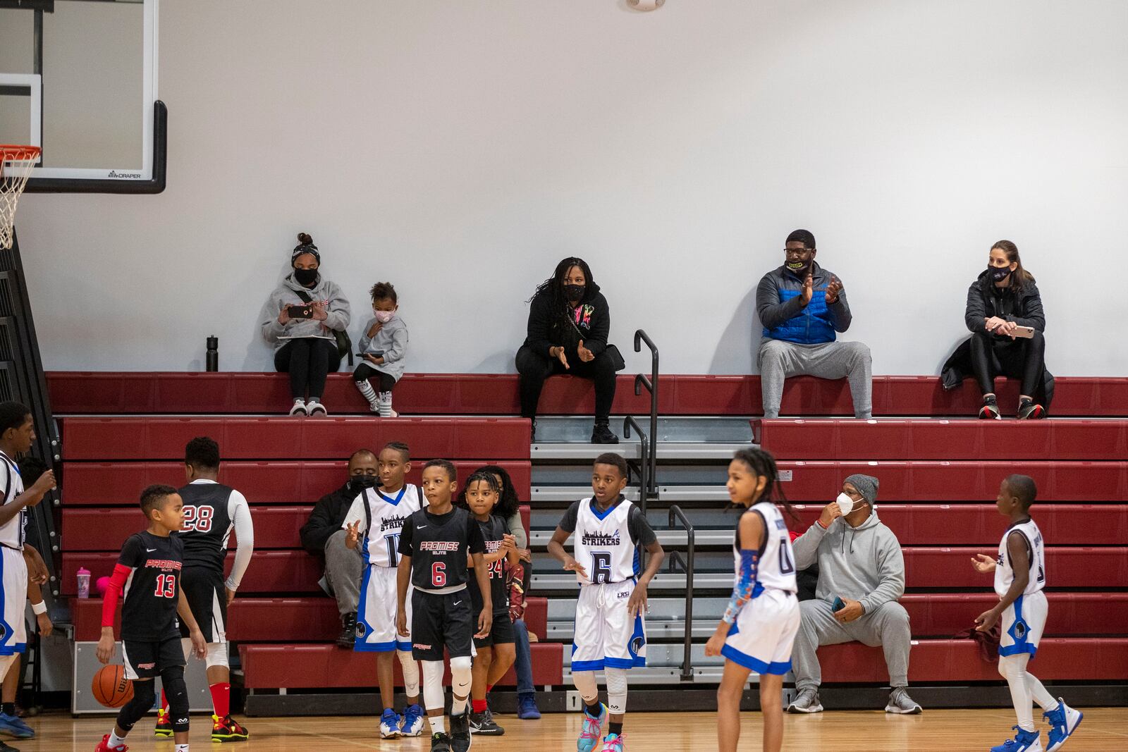 Parents and guardians of the Promise Elite basketball team sit socially distanced during a KB Sports basketball game at Hebron Christian Academy in Dacula last month. (Alyssa Pointer / Alyssa.Pointer@ajc.com)