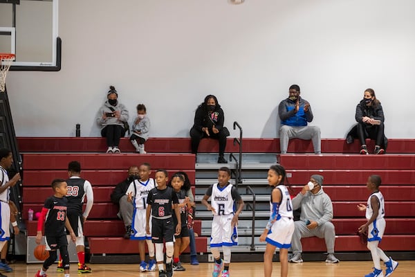 Parents and guardians of the Promise Elite basketball team sit socially distanced during a KB Sports basketball game at Hebron Christian Academy in Dacula last month. (Alyssa Pointer / Alyssa.Pointer@ajc.com)